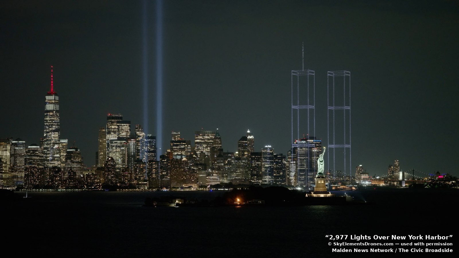 The Statue of Liberty in the foreground, with the reconstructed towers and the Tribute in Light behind
