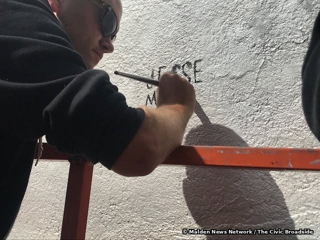 Jesse Melanson signing the mural