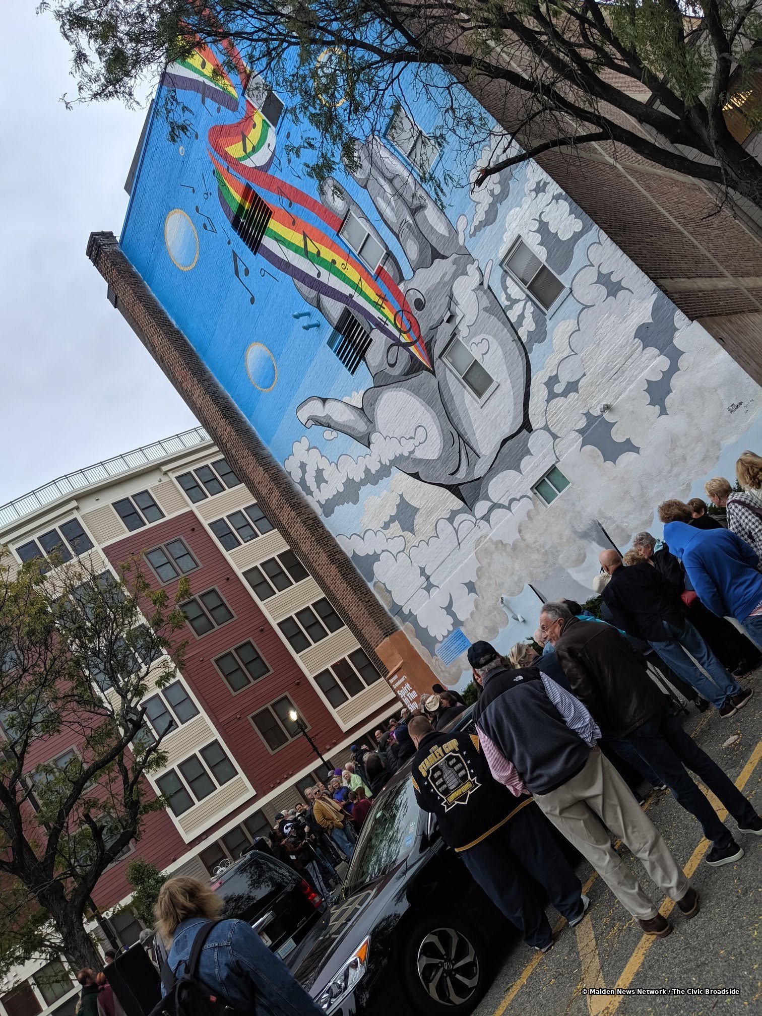 The mural's painted clouds and orbs rising skyward
